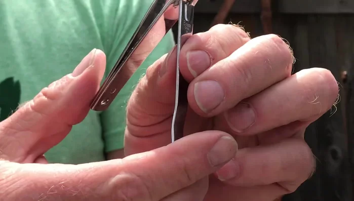 Hold the fingernail clippers as if you were about to use them, closed.