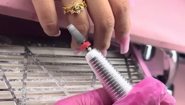 Use the 5-in-1 Pana drill bit to further refine the shape, paying close attention to blending the acrylic seamlessly with the natural nail at the cuticle for superior retention.