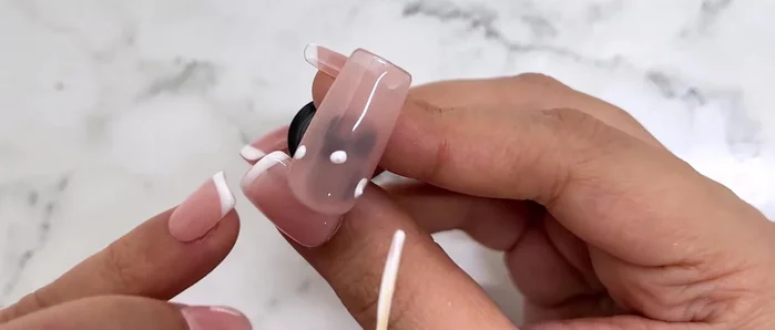 Use the dotting technique to map out a shorter, higher smile line near the cuticle.