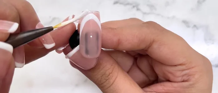 Apply white gel polish, following the created smile line.