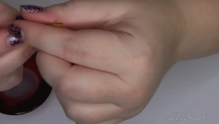 Gently lift an edge of a nail wrap using a paintbrush or orange wood stick.