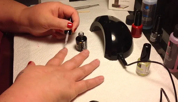 Applying yellow nail base coat