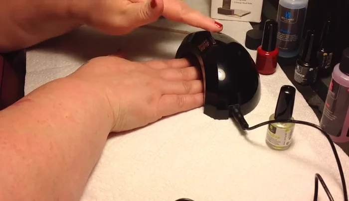 Curing gel nails under LED lamp