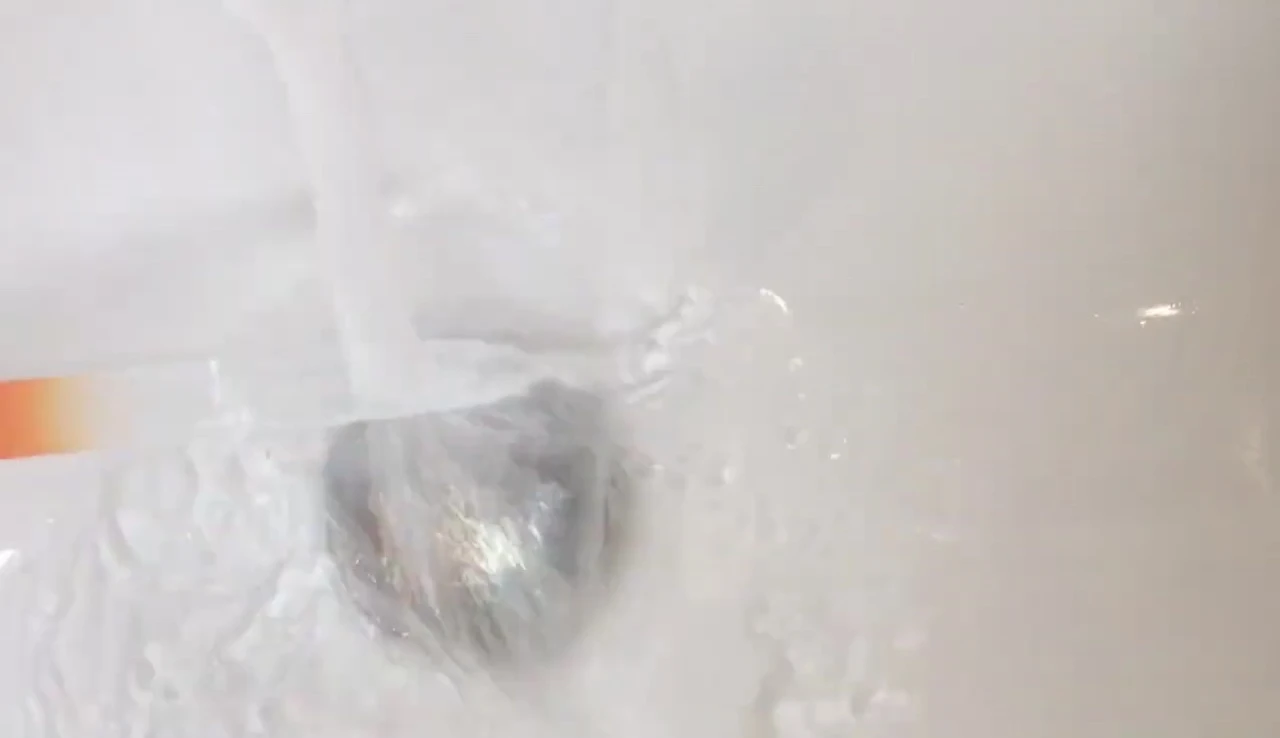 The nail file being rinsed under water.