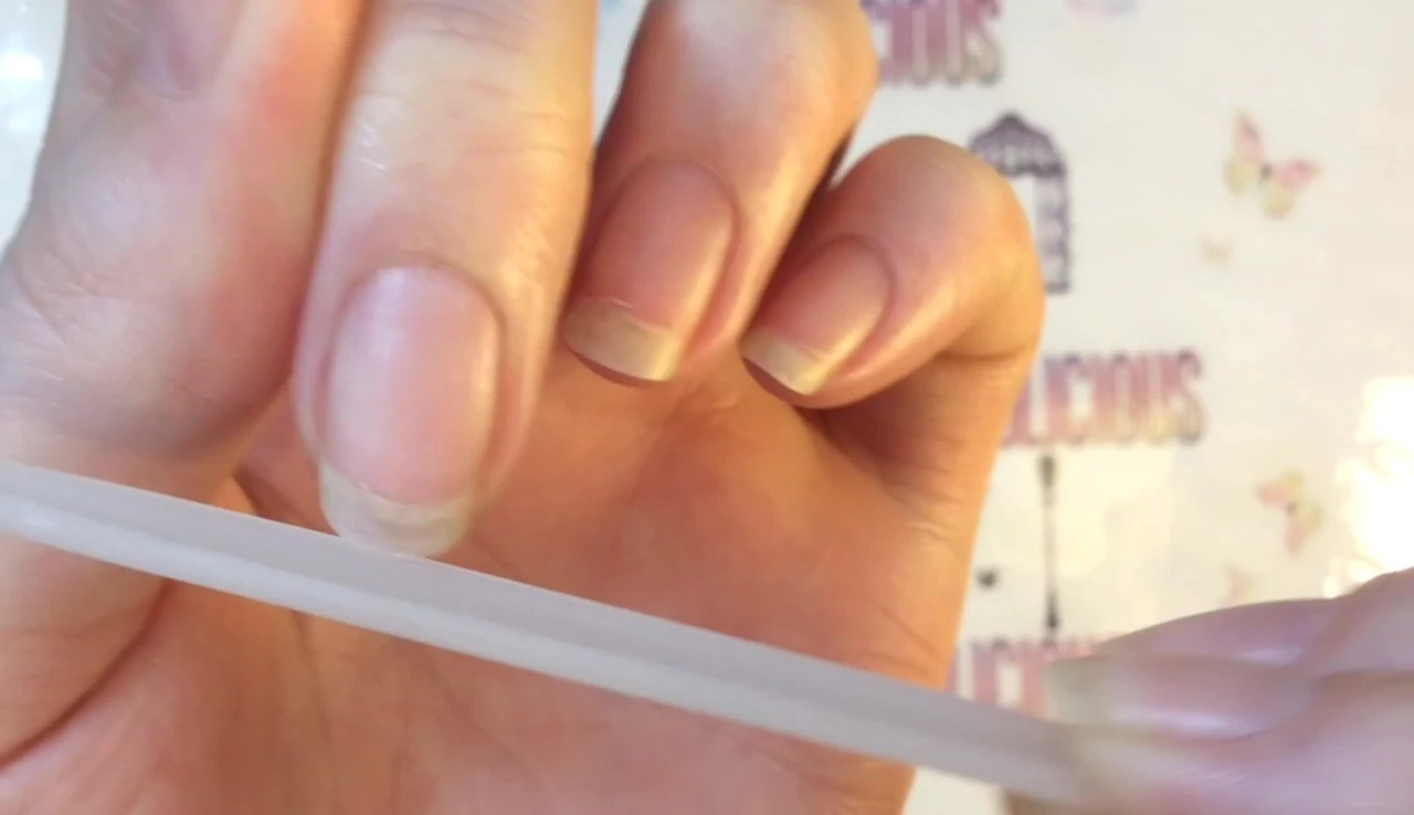 A demonstration of using the nail file on a nail.