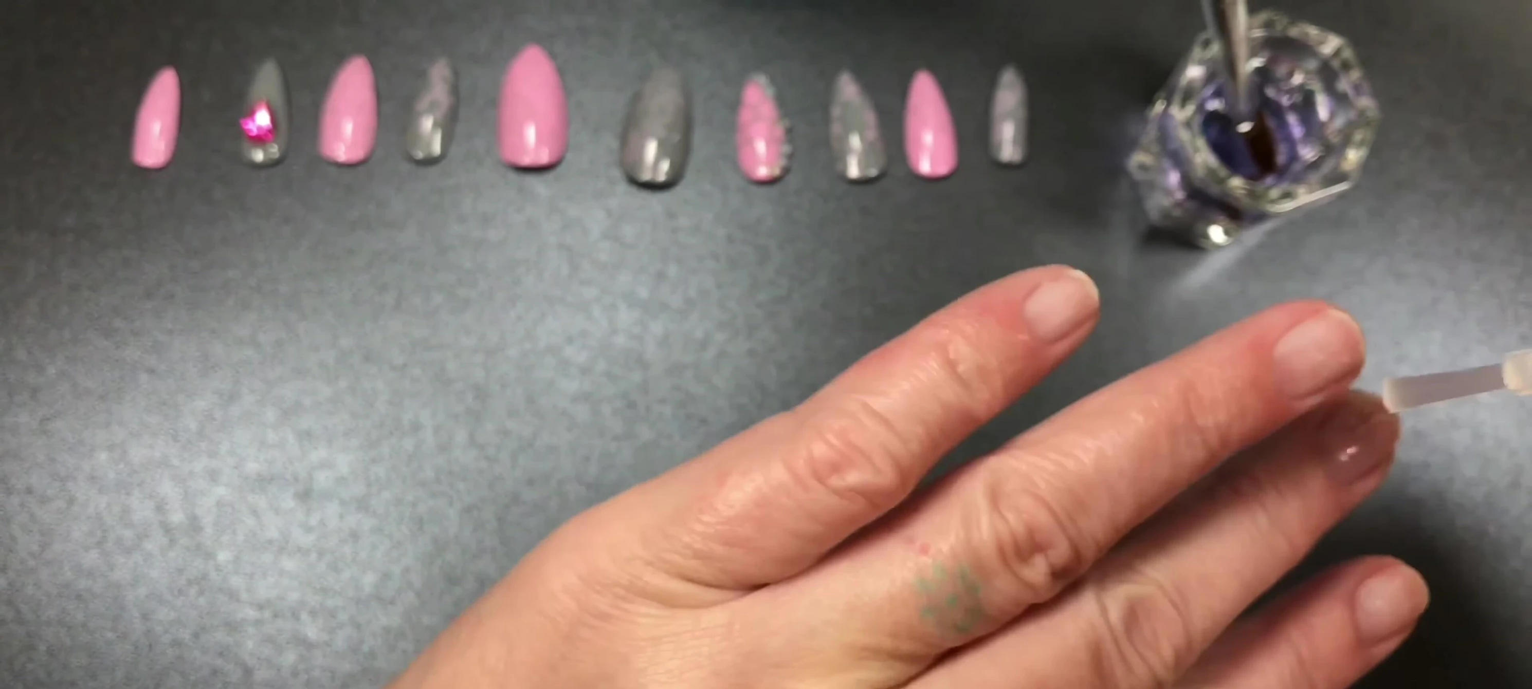 Applying acrylic to false nails.