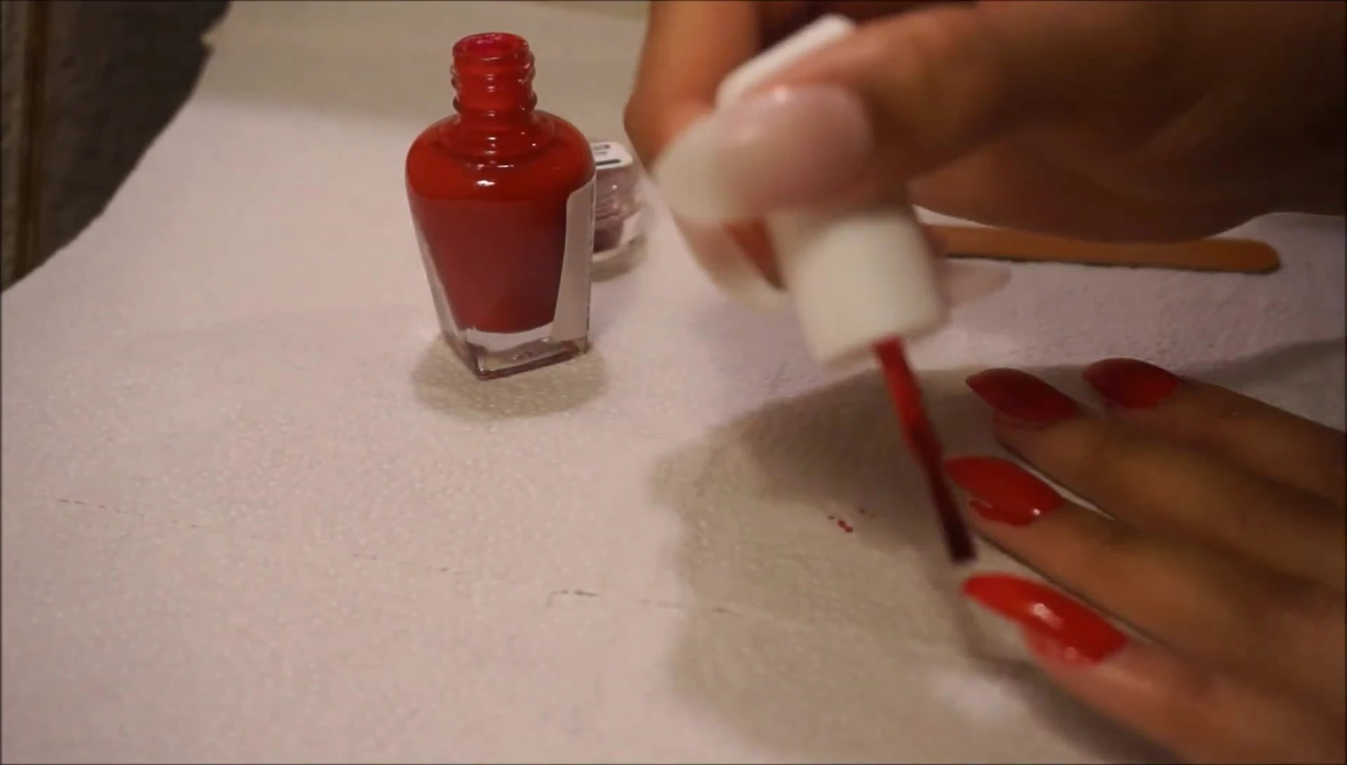 Applying glitter nail polish using a straw
