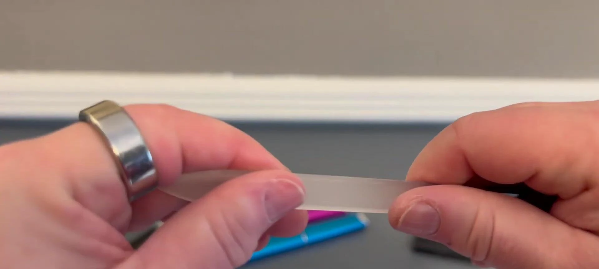 A hand demonstrating the smooth surface of the nail file.
