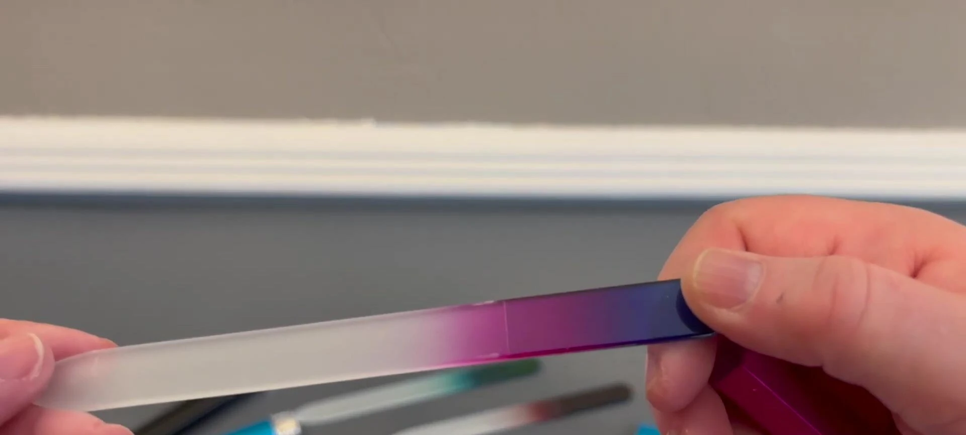 Close-up shot of the pink nail file, showcasing its deep color.