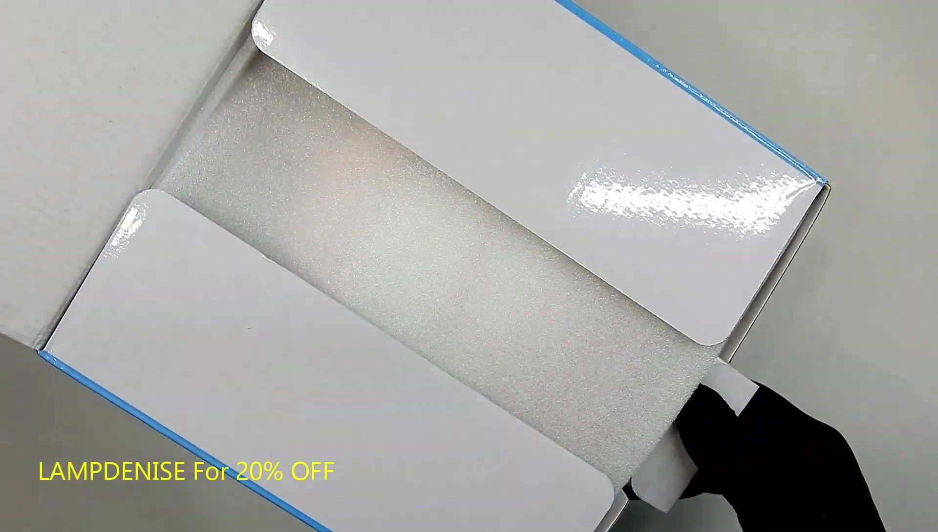The Medenia F4 lamp in its packaging, showing the protective foam.