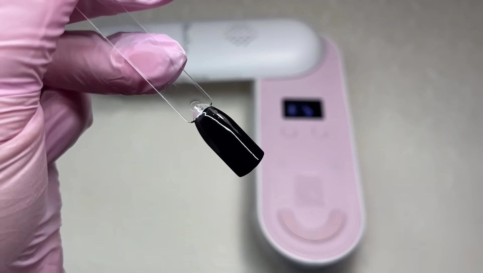 Applying black gel polish for the curing test