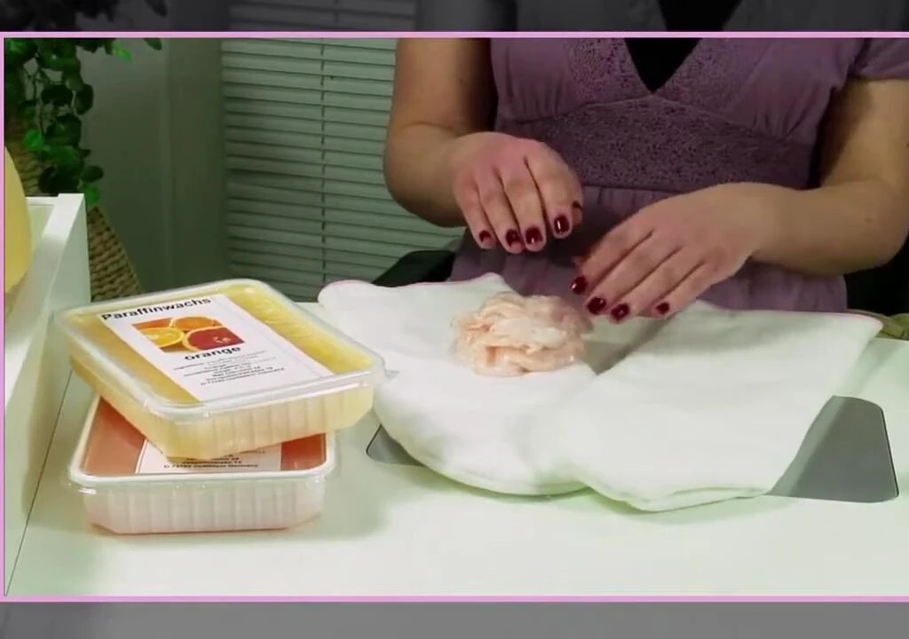 Applying hand cream or lotion after the paraffin wax treatment.