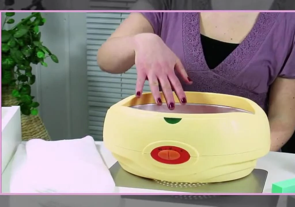 Hand being dipped into the paraffin wax bath.