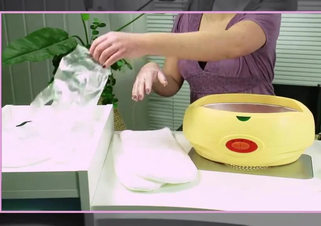 Putting on plastic and cotton gloves after the paraffin wax treatment.