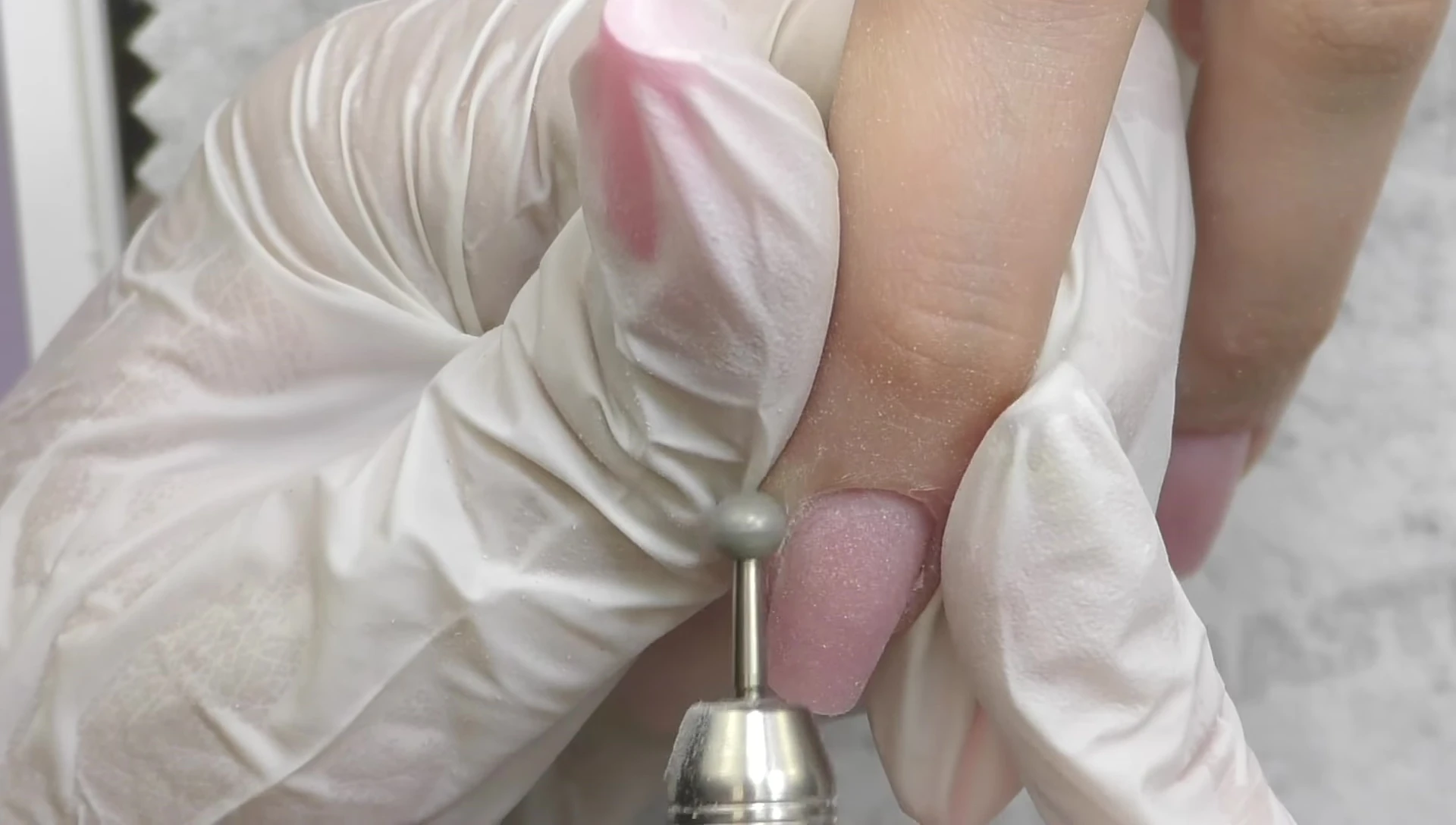 Buffing the cuticles with a diamond sphere-shaped bead.