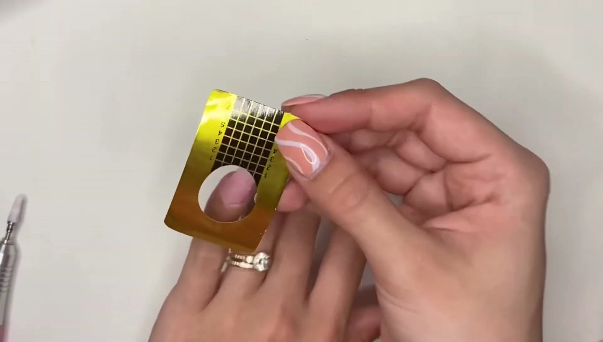 Using a paper nail form to ensure even nail length.