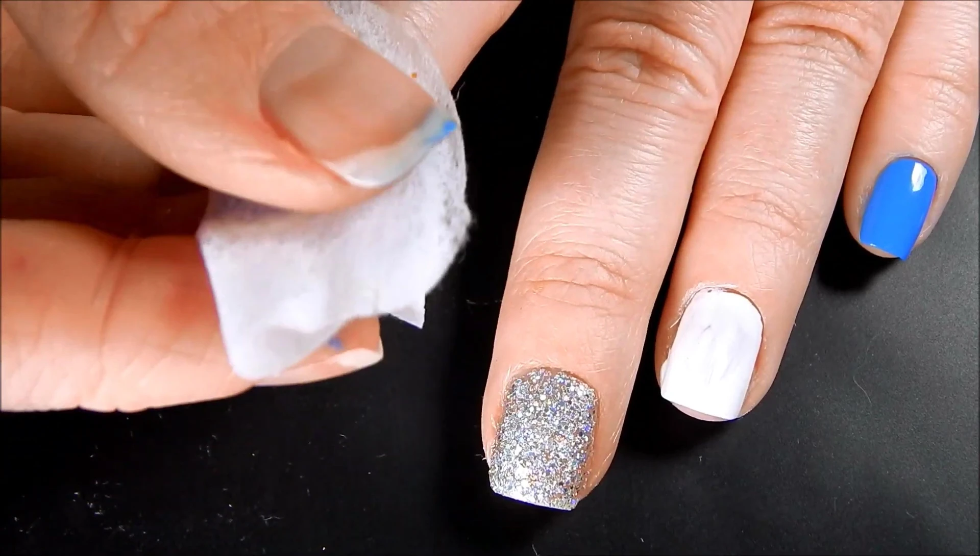 The reviewer applying a pad to a nail with regular nail polish.