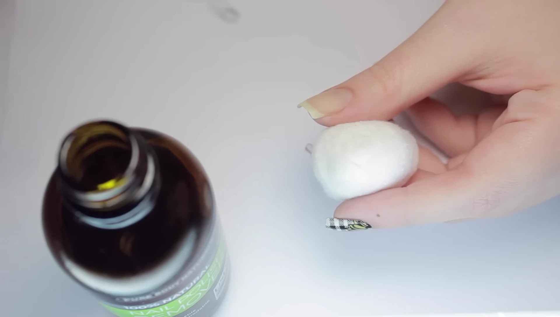 Applying the remover to a cotton ball.