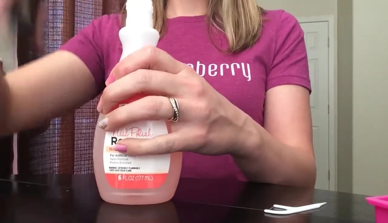 Pouring non-acetone nail polish remover into a container.
