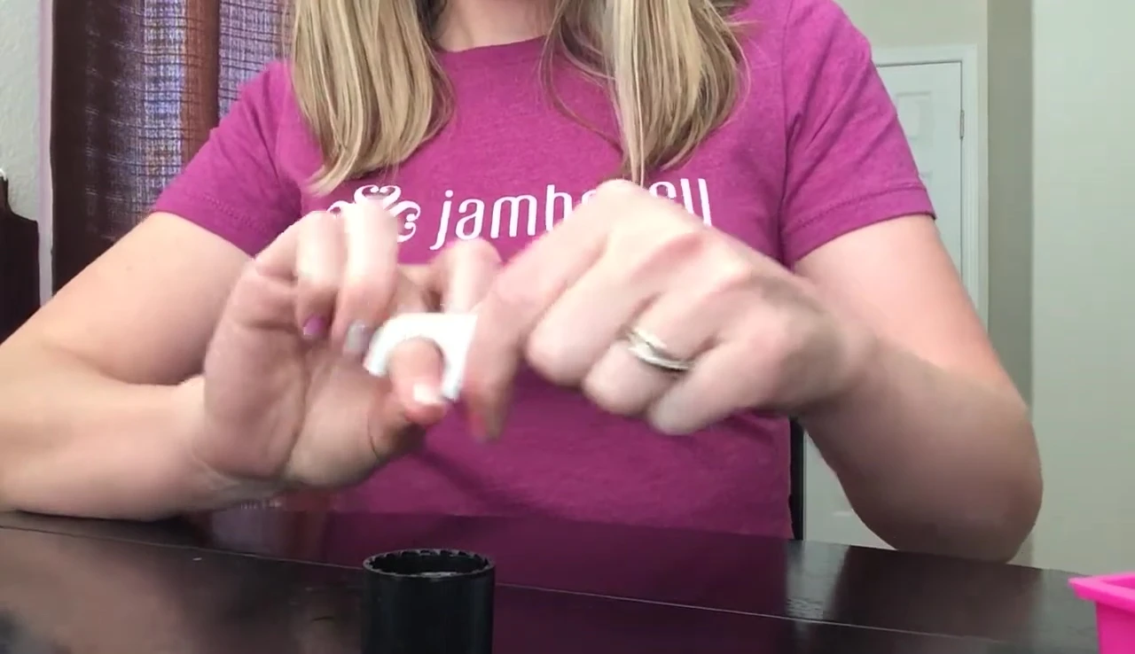 Using a floss pick to remove the nail wrap after soaking.
