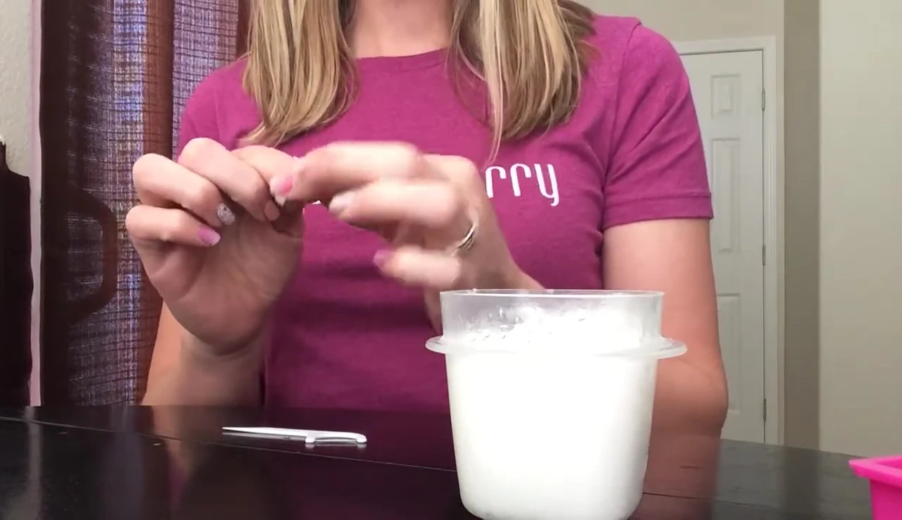 Using a floss pick to gently lift the edge of the nail wrap.