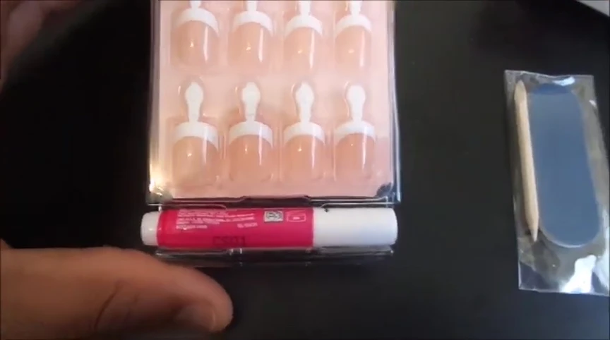 Displaying the included nail glue, cuticle pusher, and nail file.
