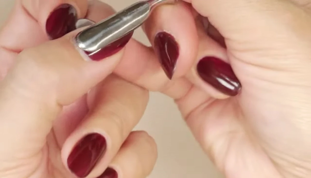 Demonstrating the technique of using the generic pusher to separate the eponychium from the cuticle.
