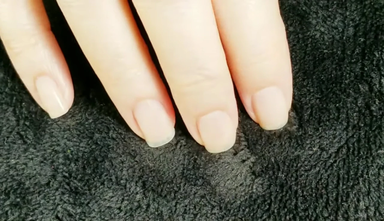 The reviewer emphasizing the strength of their nails after using the product.