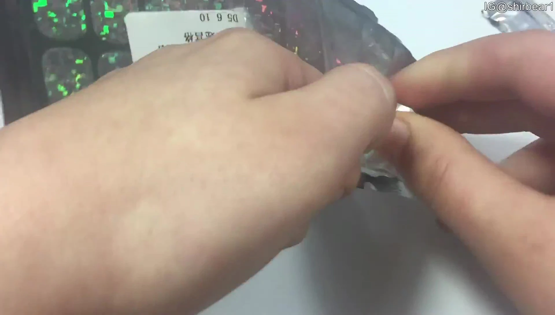 Person cutting out a nail sticker with scissors.
