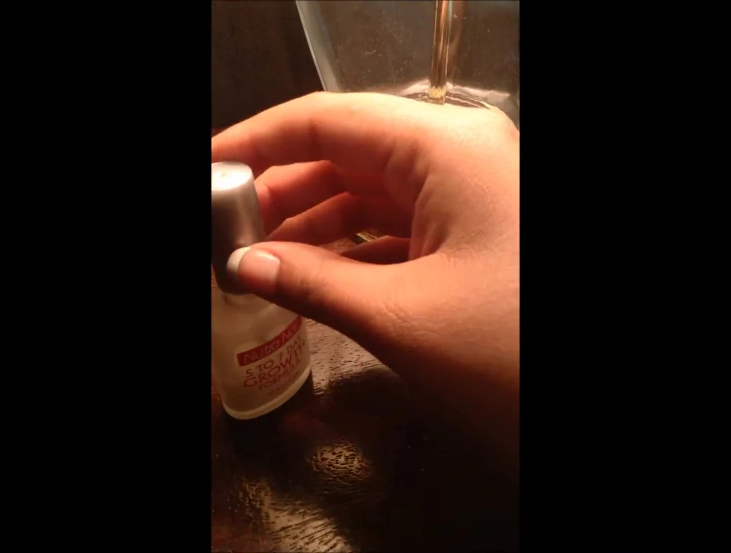 Image showing the brush applicator and the reviewer applying the product onto their nail.