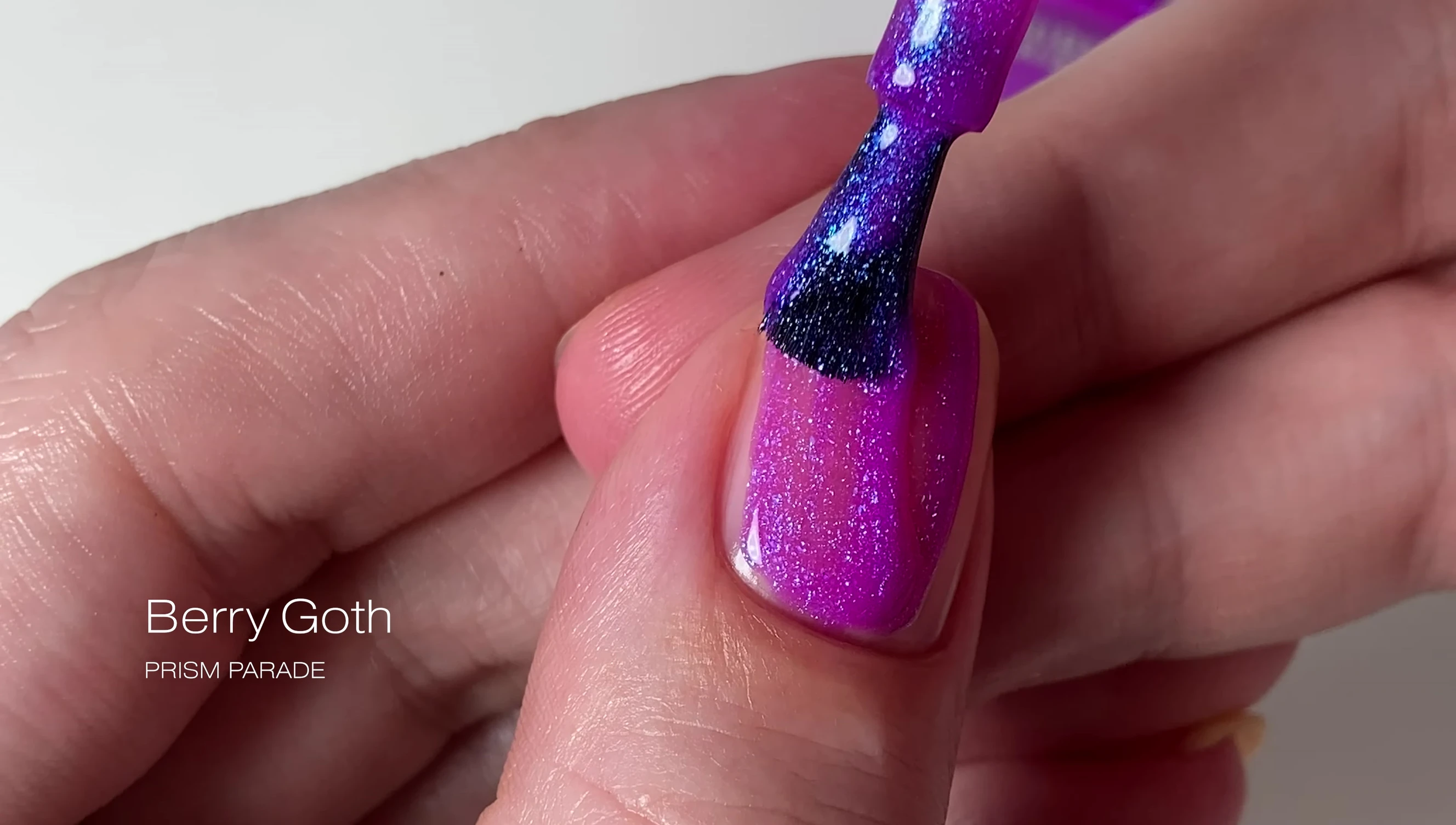 Berry Goth nail polish under UV light, showing the blue glow.
