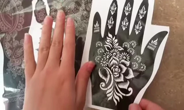 Person carefully peeling and separating finger mehndi stickers.