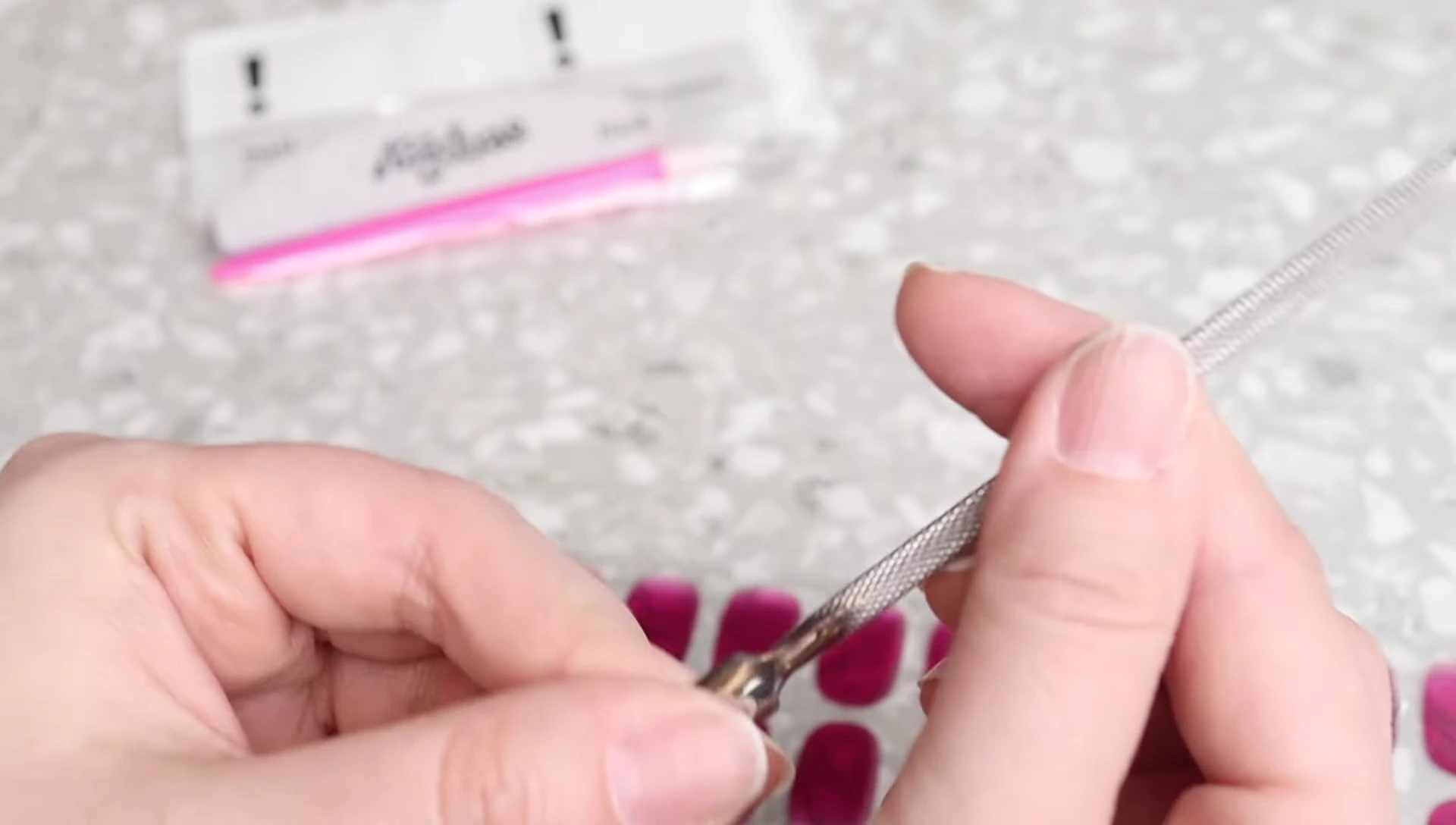 Using a metal cuticle pusher to prepare nails