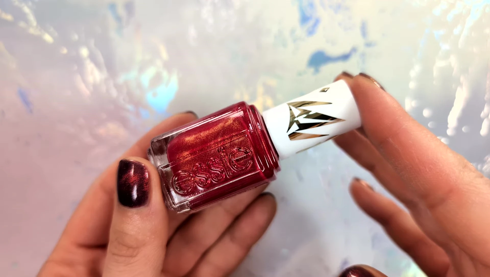 Hand model showcasing the deep red nail polish.