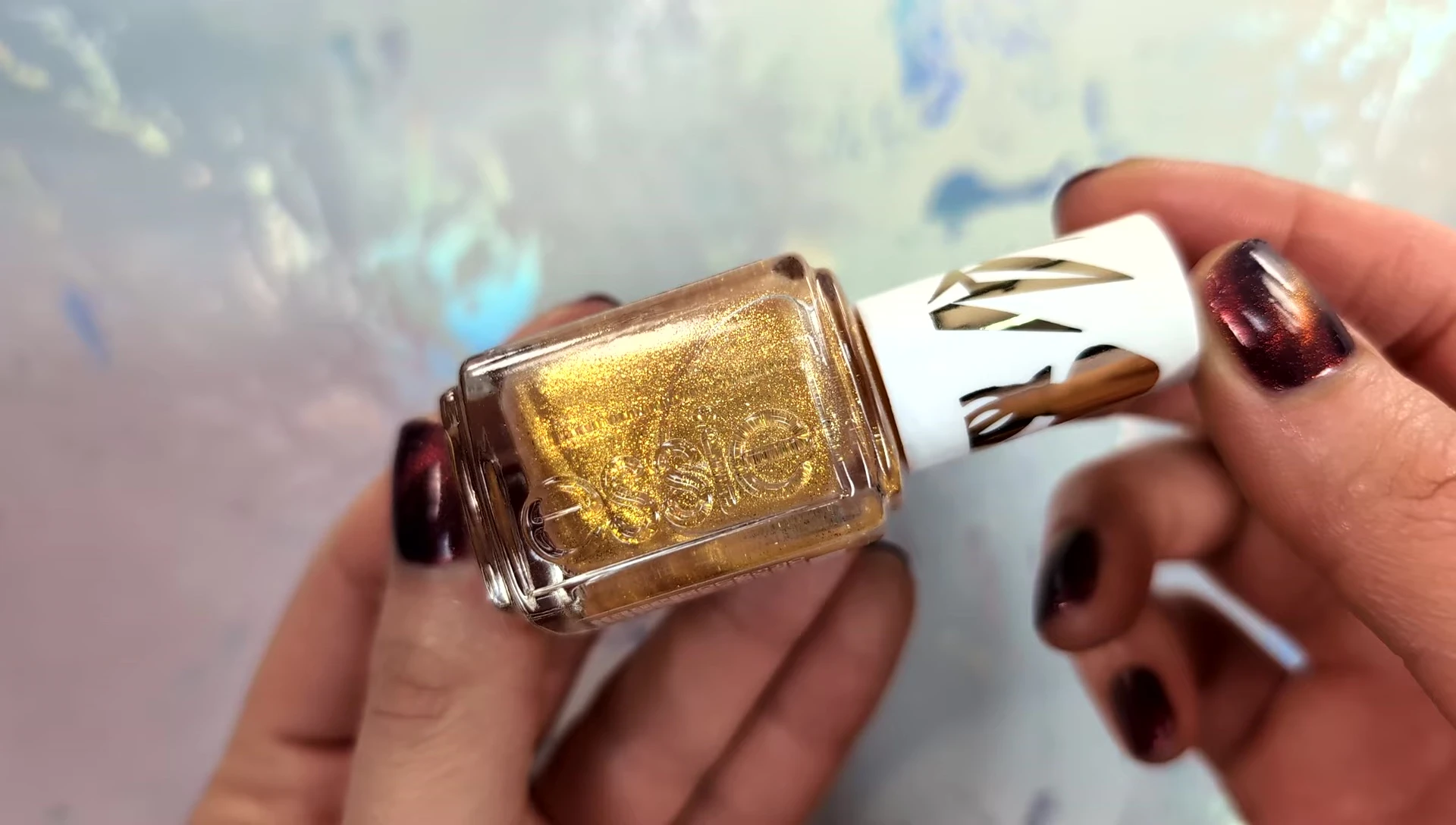 Hand model showcasing the gold pearl topper used on other shades.