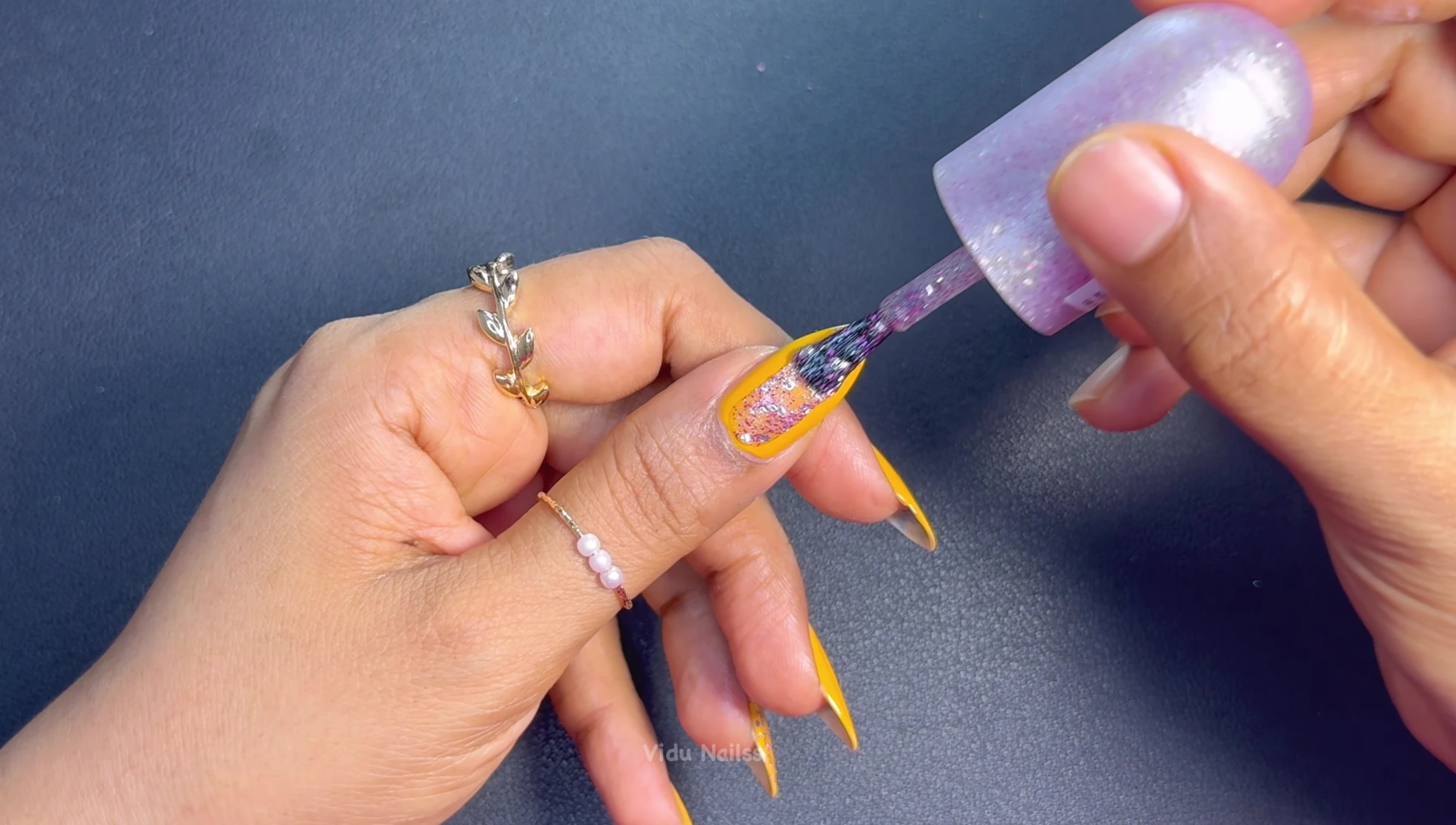 Galactic glitter topper over yellow nail polish