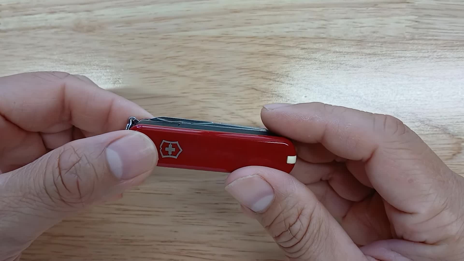 The knife being turned sideways to reveal its multiple tools.
