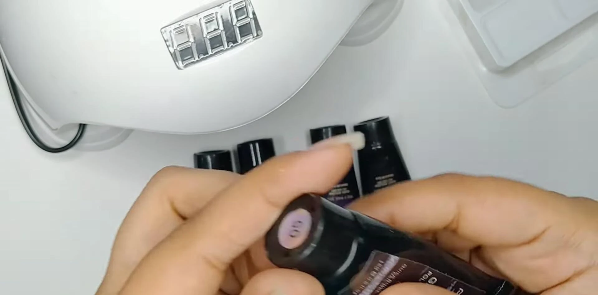 The reviewer opening the glitter polygel jar.