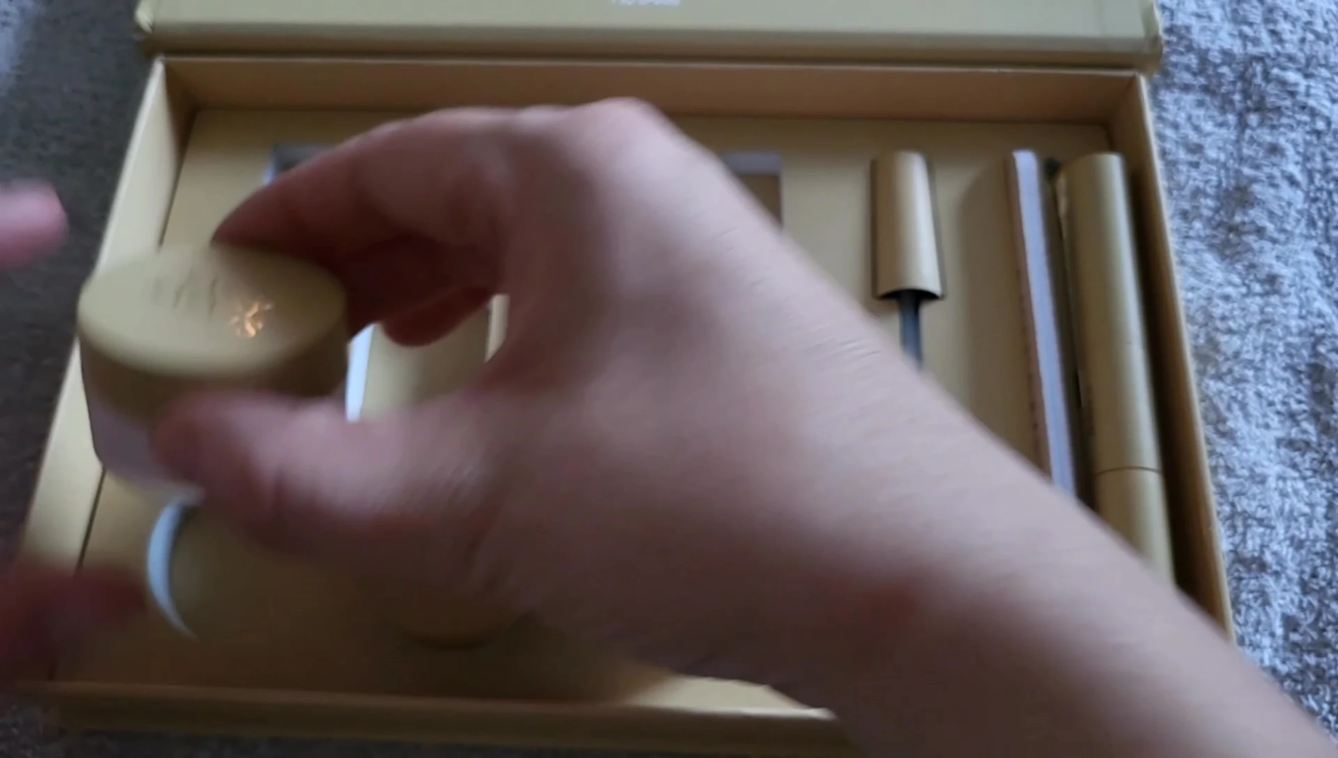 The reviewer shows the three nail polish colors included in the kit.