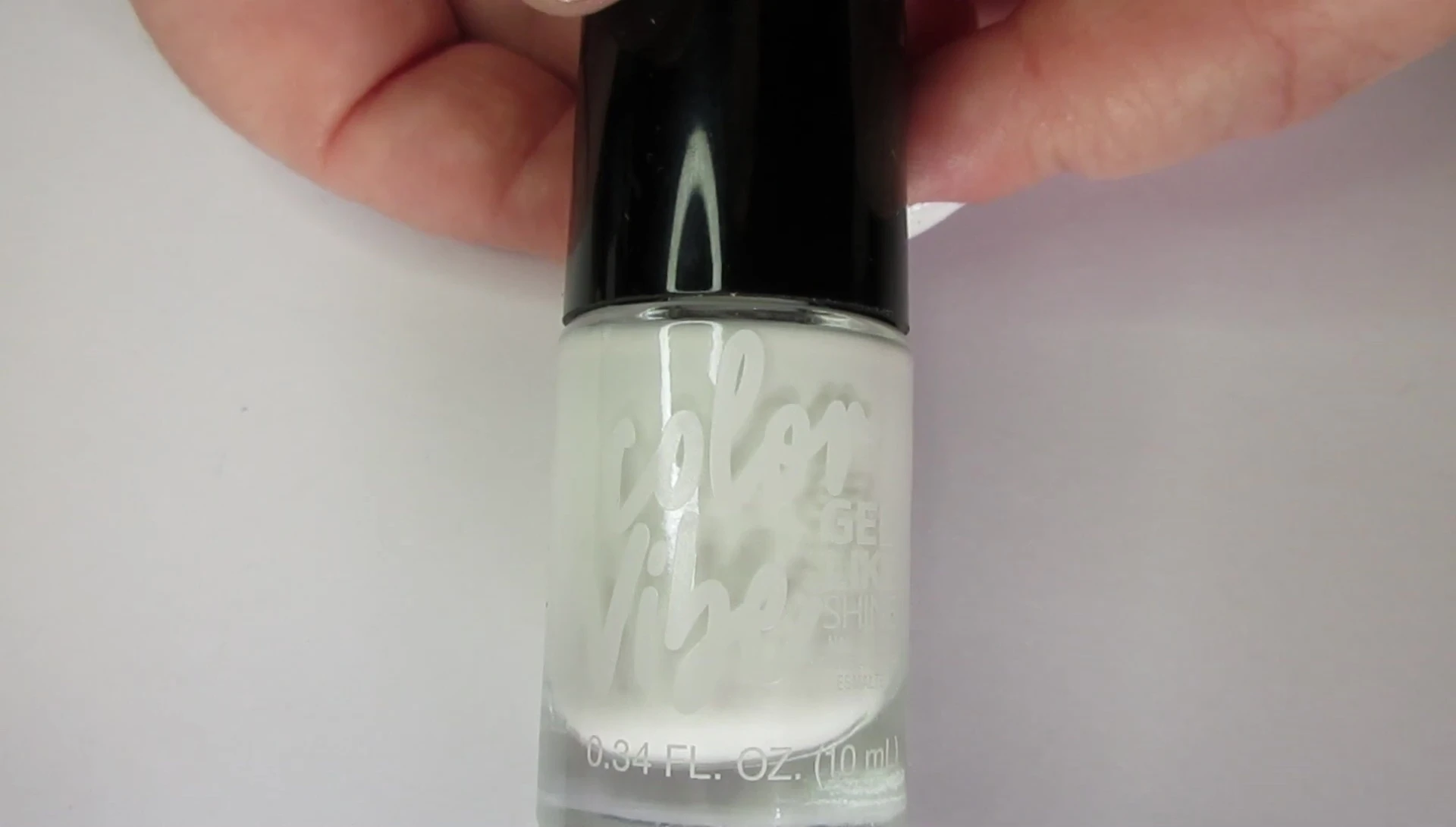 Close-up of the white nail polish being applied.