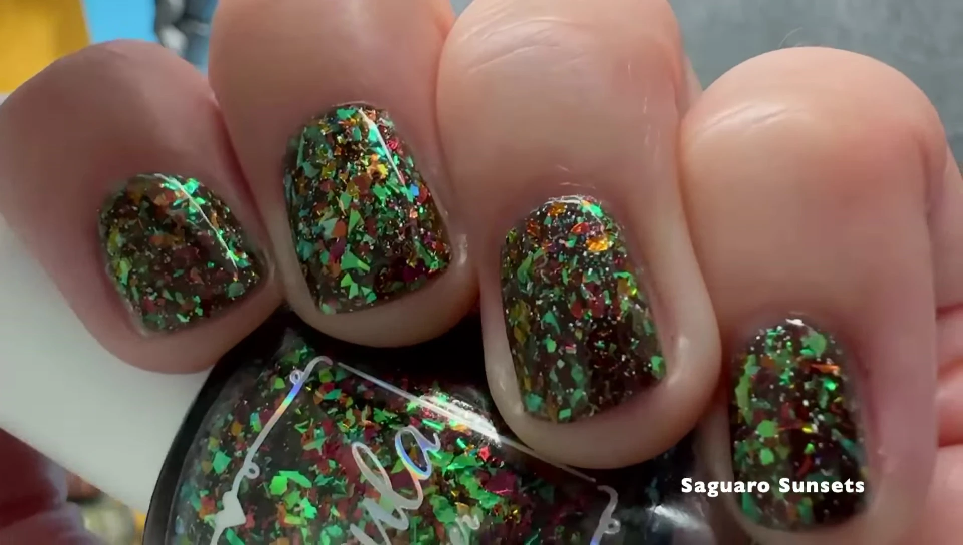 Sarro Sunset nail polish on a hand with top coat