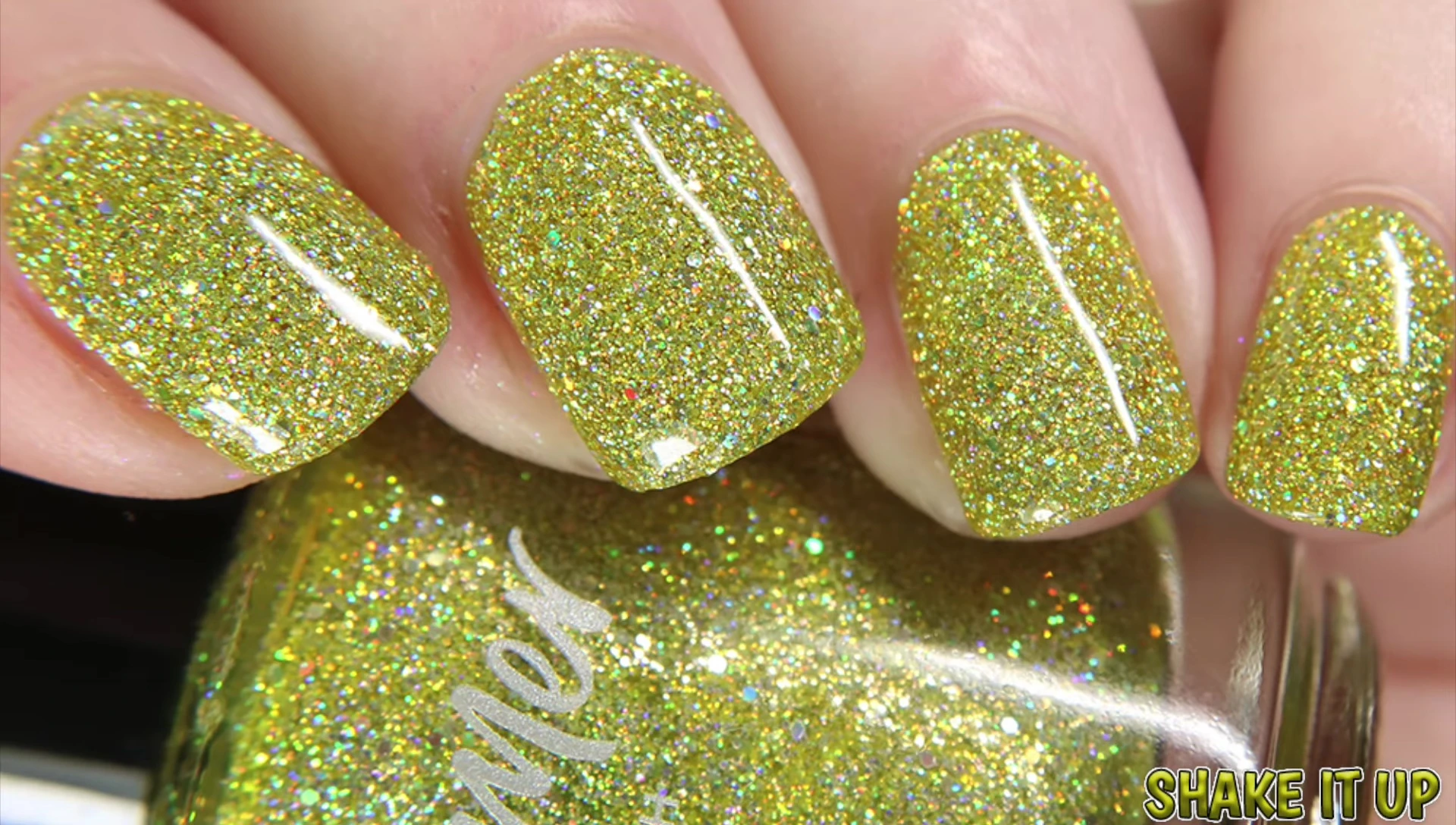 Close-up swatch of Shake It Up under natural light, showcasing the lemon yellow base and silver holo glitter.