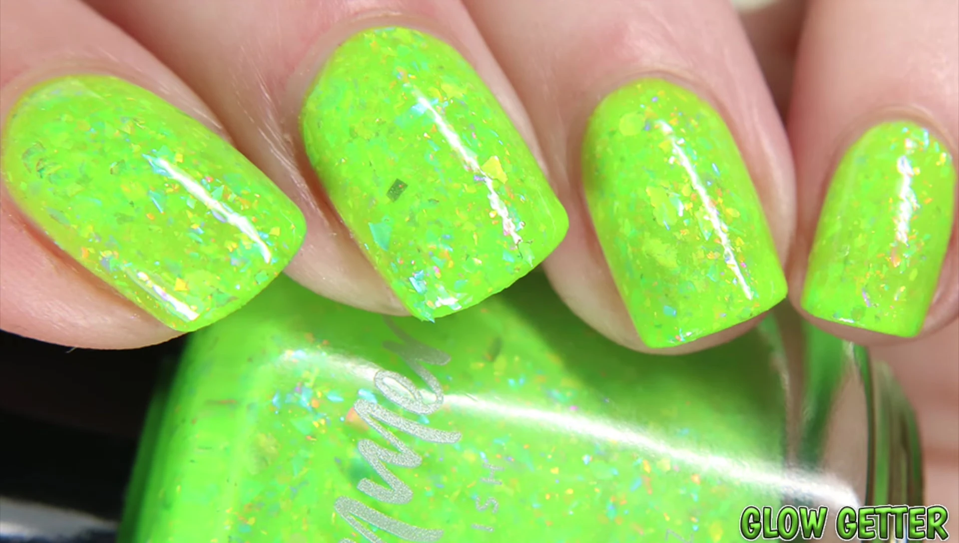 Close-up swatch of Glow Getter under natural light, displaying its neon green base and multicolored flakes.