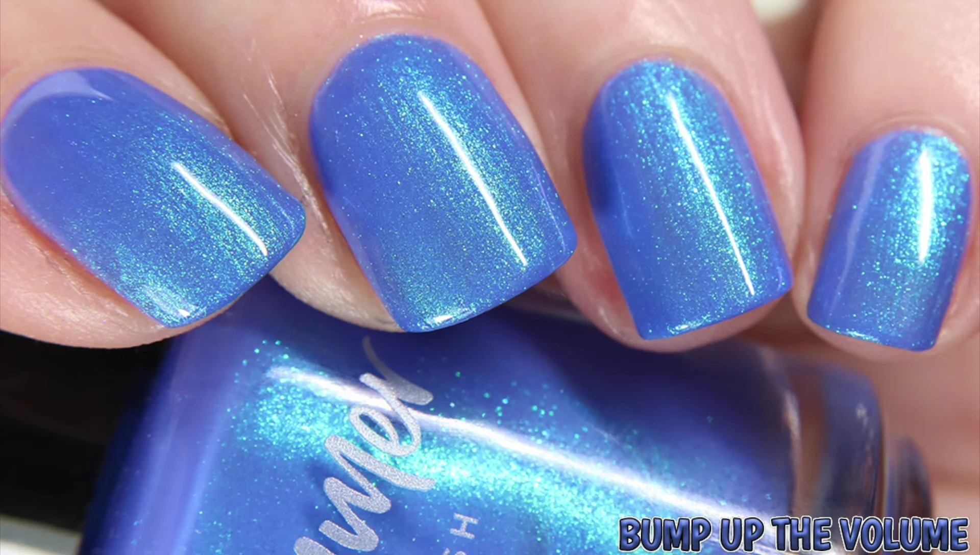 Close-up swatch of Bump Up the Volume under natural light, showing its cornflower blue base and color shifting shimmer.