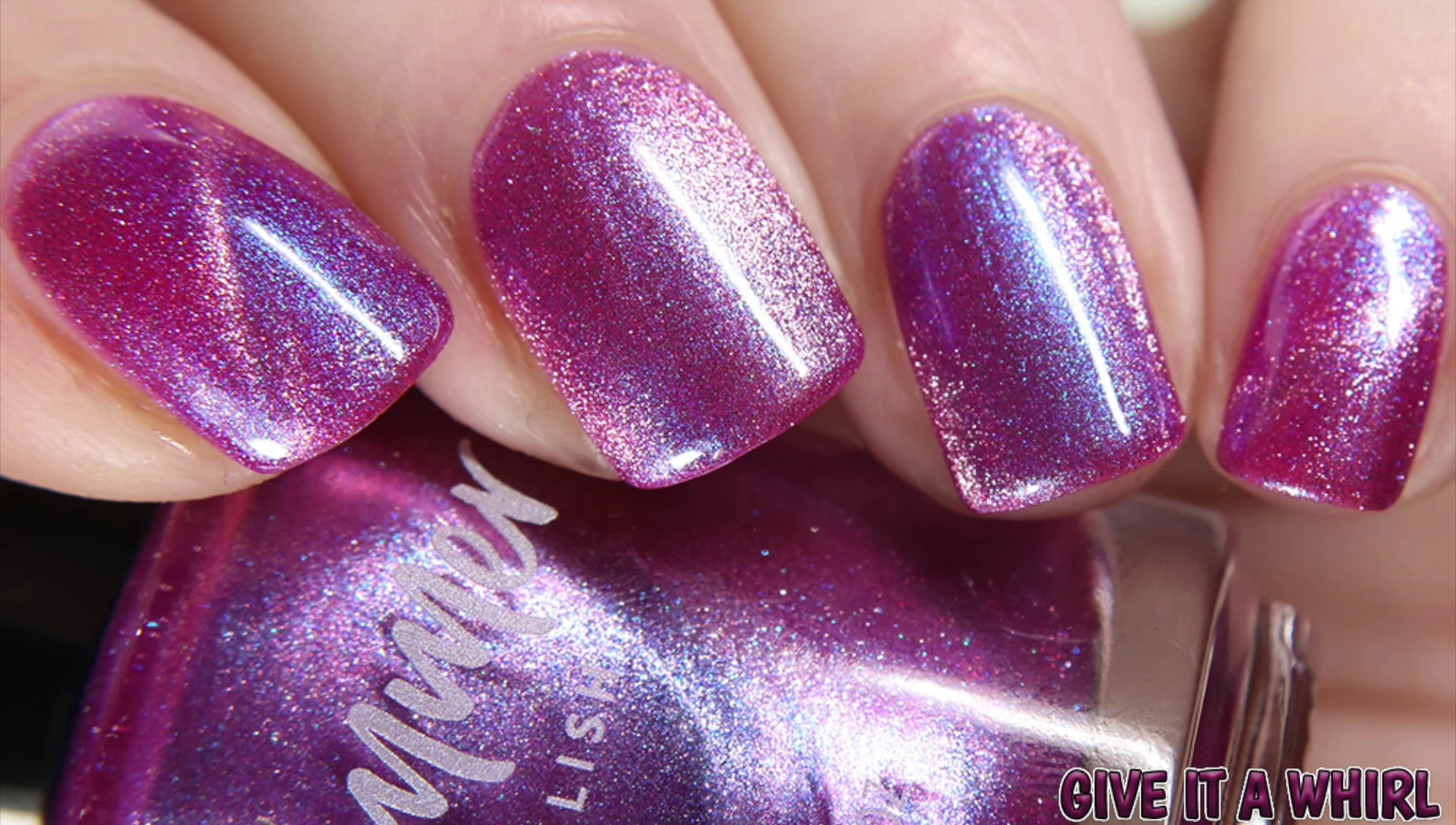 Close-up swatch of Give It a Whirl under natural light, showcasing its raspberry base, blue shimmer, and magnetic effect.
