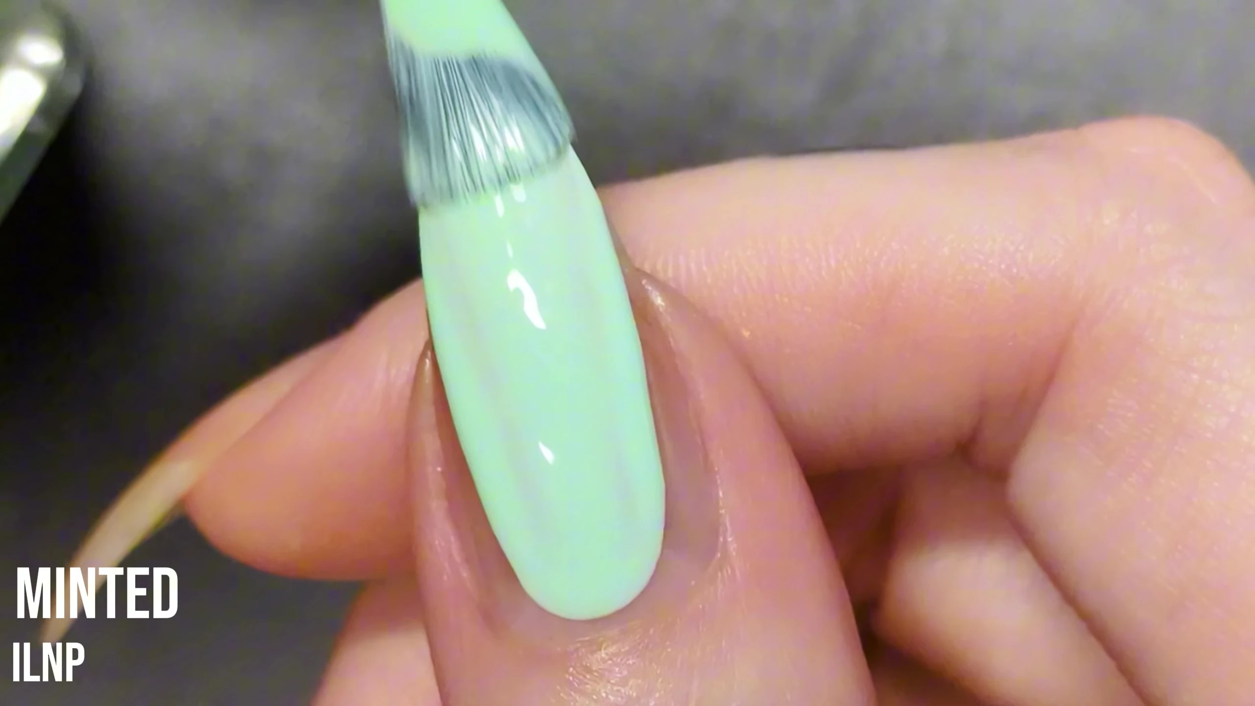 Close-up of Minted nail polish on the model's nail